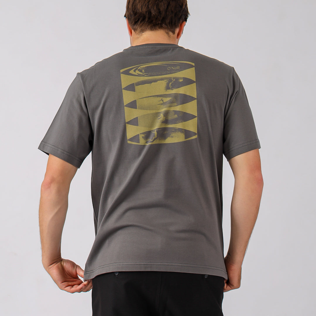 Person wearing a gray t-shirt with a graphic design on the back against a plain background