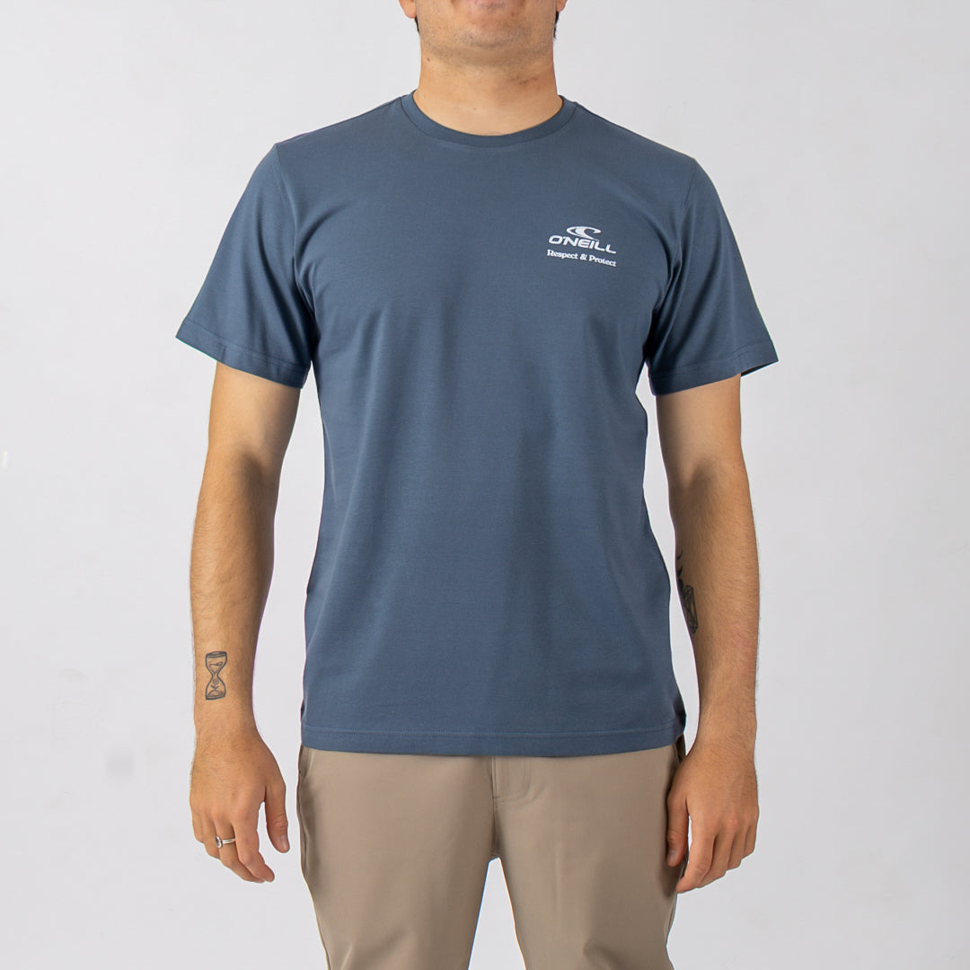 Person wearing a blue t-shirt with a logo on a plain background