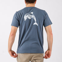 Person wearing a blue t-shirt with a dolphin design on the back against a light gray background