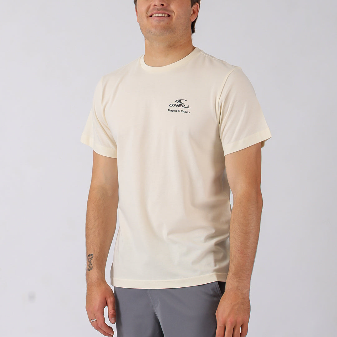 Man wearing a beige t-shirt with a logo on a plain background