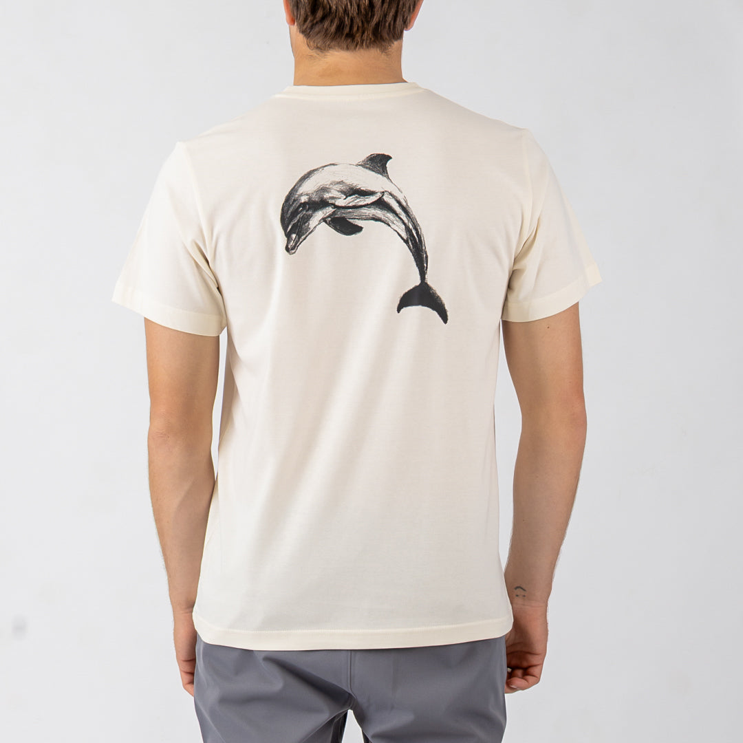 Person wearing a beige t-shirt with a dolphin graphic on the back against a white background