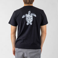 Person wearing a black t-shirt with a white turtle design on the back against a gray background