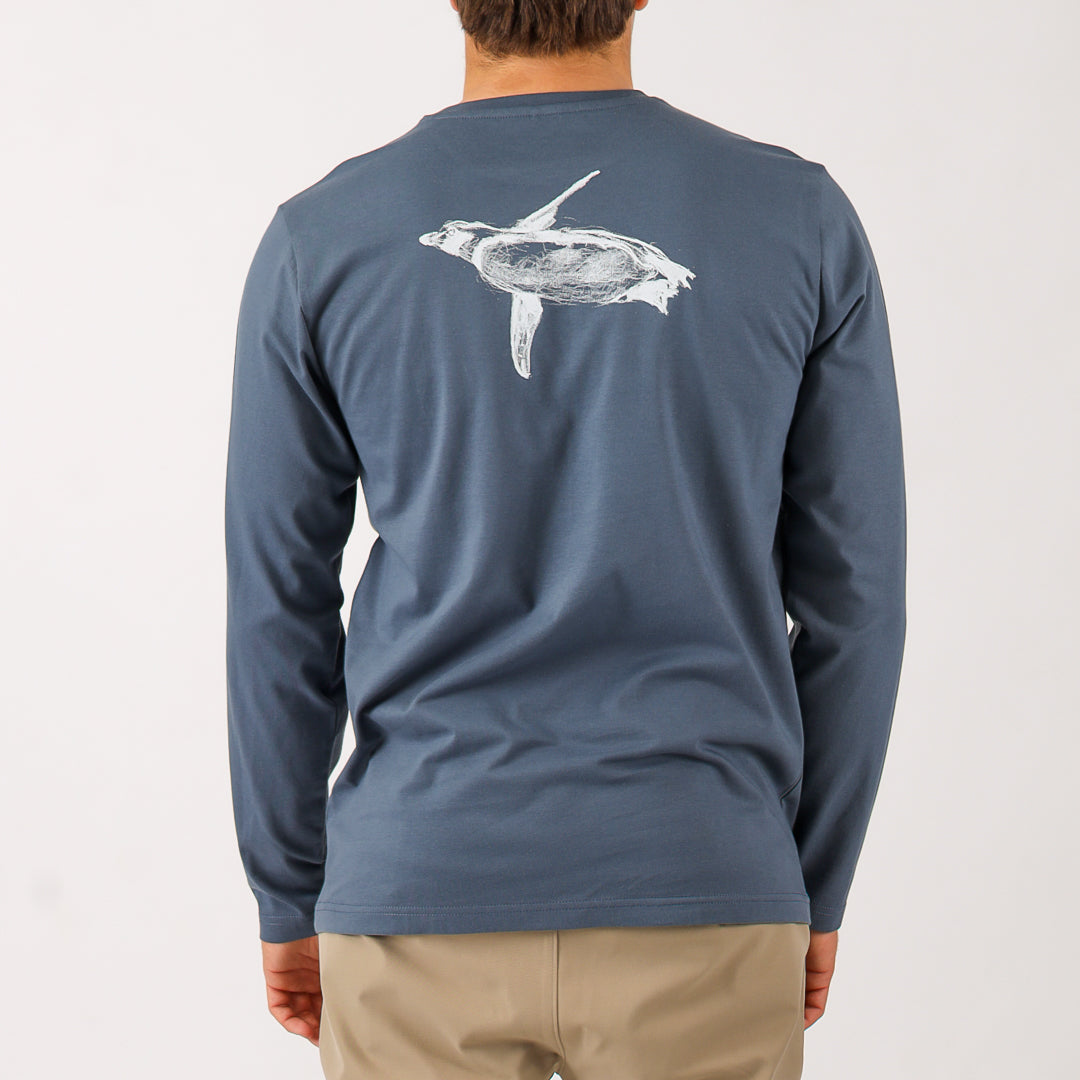 Blue long-sleeve shirt with a turtle design on the back, worn by a person.