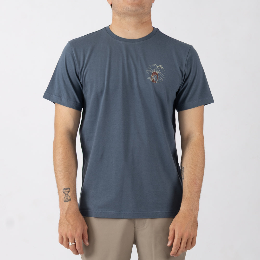 Person wearing a blue t-shirt with a small graphic on a white background