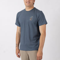 Man wearing a blue t-shirt with a small graphic on a white background