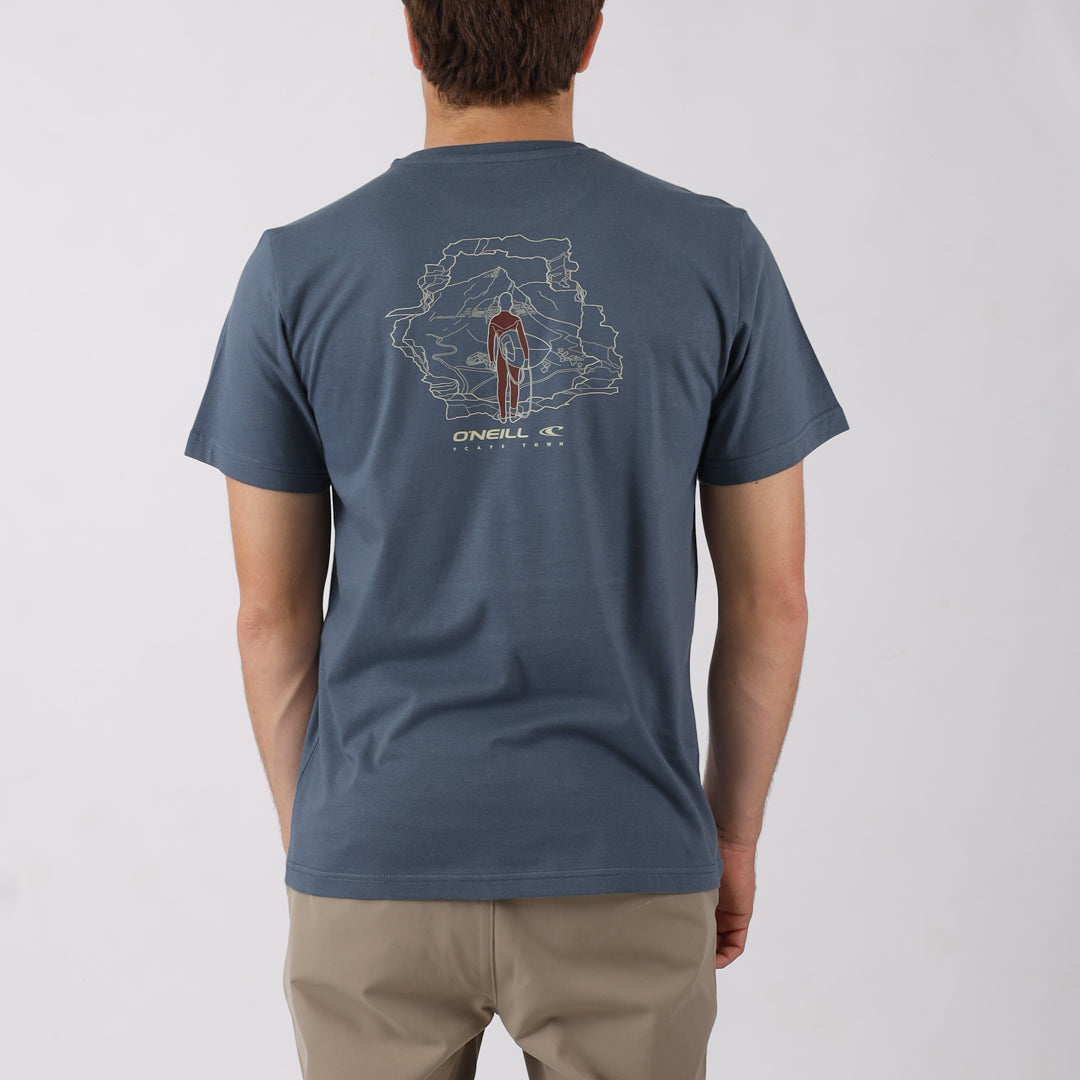 Person wearing a blue t-shirt with a graphic design on the back, standing against a plain background