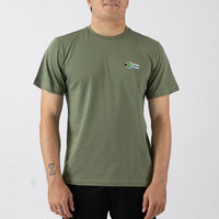 Person wearing a green t-shirt with a small logo on a white background