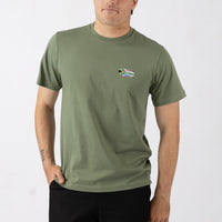 Person wearing a green t-shirt with a small logo on a white background