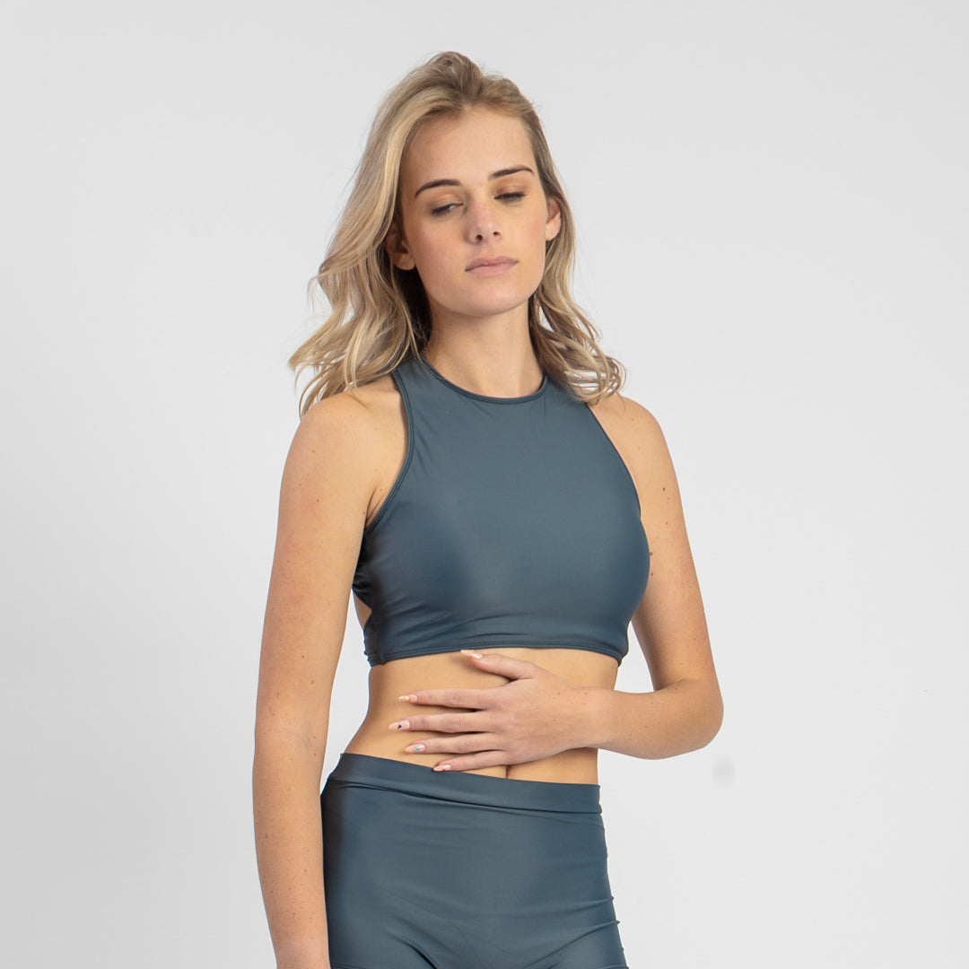 Woman wearing a teal athletic outfit on a plain background