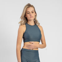 Woman wearing a teal athletic outfit on a plain background